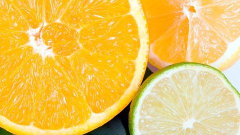 Saftige Orange und Zitrone liegen auf einem hellen Hintergrund, bereit für die Saftzubereitung.