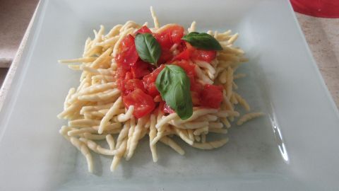 Frische, geschmolzene Tomaten auf ligurischen Trofie-Nudeln, verfeinert mit Basilikum – ein einfaches Sommergericht aus Italien.