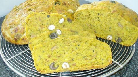 Ein frisch gebackenes, knuspriges Brot liegt auf einem Gitter, umgeben von hellen Küchenwänden. Es ist schnell gemacht.