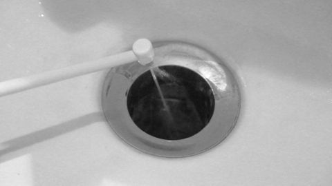 Eine Munddusche spritzt Wasser in den Abfluss, um ihn zu reinigen und Verstopfungen zu lösen.