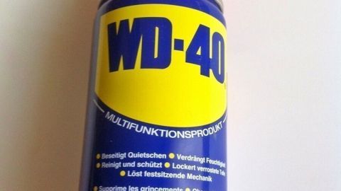Ein WD-40 Spray ist auf einem weißen Hintergrund zu sehen, bereit zur Anwendung gegen Lackkratzer am Auto.