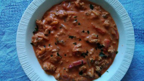 Eintopfgericht in einer Schüssel, es ist eine cremige Hacksuppe, umgeben von einer blauen Tischdecke.