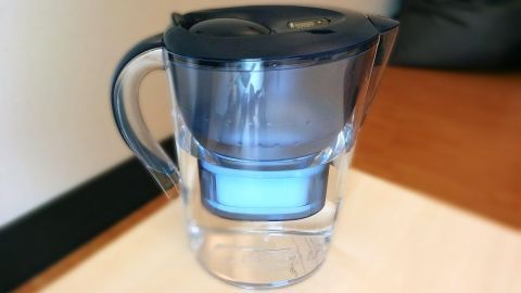 Ein Wasserfilter steht auf einem Tisch und wirkt bereit, Wasser zu filtern: eine sinnvolle Anschaffung für Haushalte.