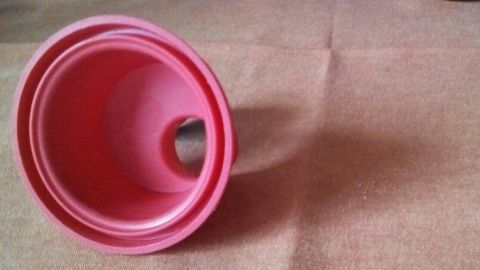 Ein praktischer Marmeladentrichter steht schräg auf einem Tisch, bereit, Marmelade in Gläser zu gießen.