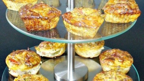 Auf einer eleganten Glasplatte stehen goldbraune Muffins ohne Mehl, frisch gebacken und bereit zum Genießen.