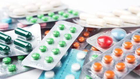 Bunte Pillen und Tabletten liegen verstreut auf einem Tisch und symbolisieren den Medikamentenentzug und mögliche Herausforderungen.