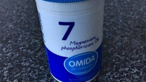 Ein Behälter mit blauer Kappe enthält Magnesiumphosphat, um Unterstützung bei Reizhusten zu bieten.