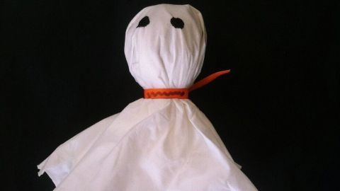 Ein Lolli-Geist schwebt in der Mitte, mit einem weißen Tuch als Körper und einer orangefarbenen Schnur um den Hals.