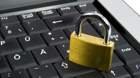 Ein Vorhängeschloss steht auf einer Laptop-Tastatur, was auf Sicherheit gegen Computer-Viren hinweist.