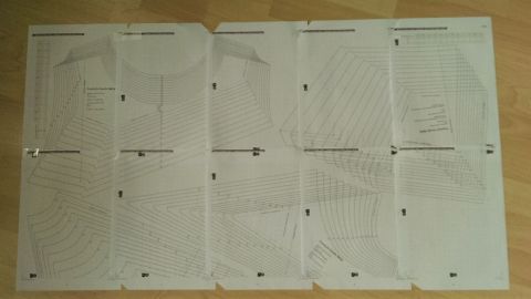 Mehrere gedruckte Schnittmuster liegen zusammengeklebt auf einem Tisch, bereit zum Ausschneiden und Nähen.