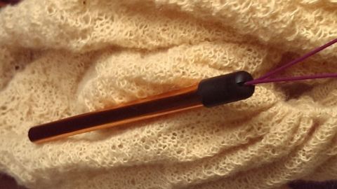 Holzstricknadeln liegen auf einem hellen, gewellten Stoff. Sie sind stabil und brechen nicht mehr, ideal für Handarbeiten.