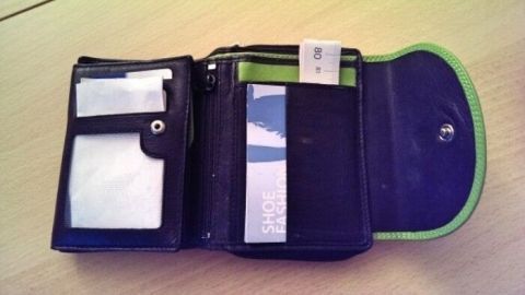 Ein Maßband liegt in einer offenen Geldbörse, umgeben von Kartenfächern, bereit für den schnellen Gebrauch unterwegs.