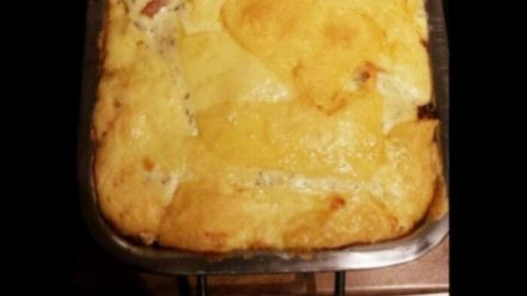Eine goldbraune Zucchini-Lasagne ohne Nudeln liegt in einer Blechform auf dem Herd und ist bereit zum Servieren.