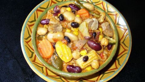 Eine bunt belegte Schüssel mit 'Dosenbohnensuppe' und Fleisch zeigt eine Mischung aus Bohnen und Gemüse in einer freundlichen Umgebung.