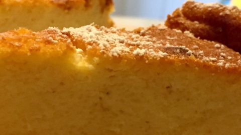 Ein goldbrauner Käsekuchen ohne Boden steht in einer hellen Küche, bereit zum Servieren und Genuss.