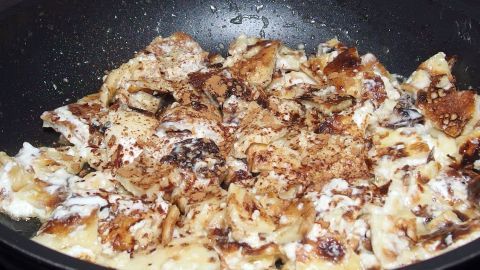 In einer Pfanne braten übrig gebliebene Pfannkuchen, die knusprig und leicht angebrannt sind, um sie lecker zu verwerten.