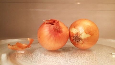 Manche Zwiebeln lassen sich einfach nicht gut schälen, die Schale sitzt zu fest an der Zwiebel. Mit diesem einfachen Trick geht es kinderleicht. Zwei Zwiebeln liegen auf einem Mikrowellen-Teller, während eine Schale abgeblättert ist. Zwiebeln leichter schälen.