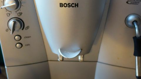 Eine Kaffeemaschine von Bosch steht auf einem Küchentisch und hat eine Abtropfschale, bereit zur Reinigung der Brühgruppe.