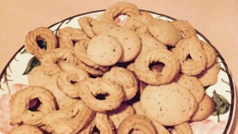Ein Teller mit goldbraunen Marzipan-Mandel-Ringen, kunstvoll angerichtet und bereit zum Genießen.
