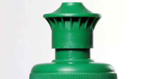 Eine grüne Flasche hat einen speziellen Deckel, der zum präzisen Befüllen des Bügeleisens dient, um Wasser einzufüllen.