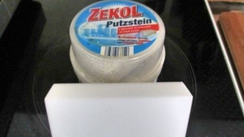 Ein Putzstein steht auf einer glatten Fläche und wird verwendet, um schwarze Streifen in der Toilettenschüssel zu entfernen.