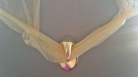 Ein transparentes Band umschlingt einen glänzenden, ovalen Verschluss in einem hellen Raum.
