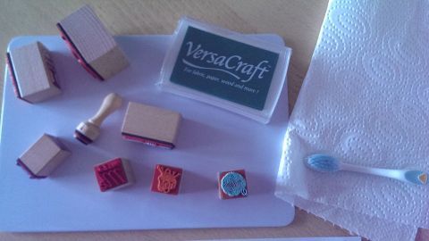 Filigran gearbeitete Stempel liegen auf einem Tisch, während eine Zahnbürste zum Reinigen bereitsteht.
