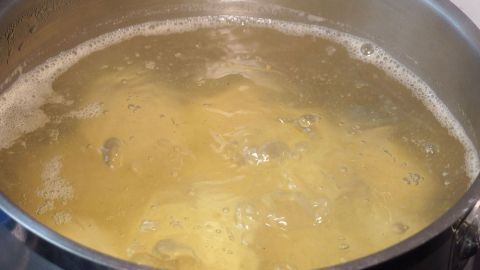 Kochen von Kartoffeln in einem Topf mit sprudelndem Wasser, um sie weich zu machen, während Blasen aufsteigen.