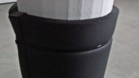 Ein schwarzer Schutz um einen Säulenpfeiler in einer Garage, um das Auto vor möglichen Schäden zu bewahren.