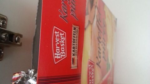 Eine Twix®-Verpackung liegt in einem Schrank neben einer Box, die Süßigkeiten clever vor Kindern versteckt.