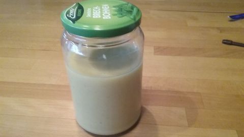 Ein Glas mit Zitronenpaste steht auf einem Holzbrett, bereit zur Verwendung für die Reinigung von Edelstahl.