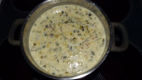 Eine große Suppenpfanne mit cremiger Lauch-Kartoffelsuppe steht auf dem Herd und dampft köstlich.