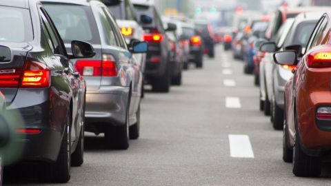 Stau von Autos auf einer mehrspurigen Straße, während die Fahrzeuge stillstehen und Umgebung unscharf bleibt.