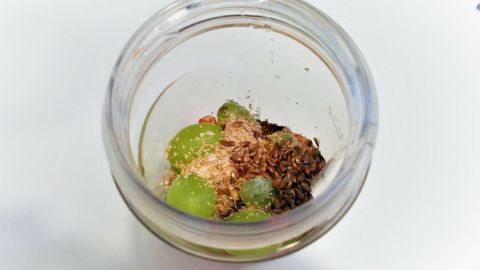 Ein Glas mit grünem Obst und nahrhaften Zutaten wird frisch zubereitet, um die Verdauung mit Smoothies zu fördern.