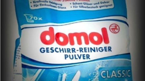 Ein Reinigungspulver steht im Vordergrund und zeigt, wie man stark verschmutzte Hände mit Geschirr-Reiniger reinigt.