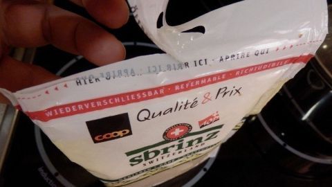 Eine Hand hält einen wiederverschließbaren Produktbeutel, der gerade geöffnet wird, um den Inhalt sichtbar zu machen.