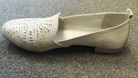 Ein eleganter Schuh mit durchbrochenem Design liegt auf einer grauen Oberfläche, perfekt für den modischen Alltag.