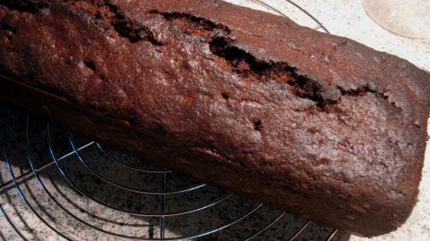 Der Schoko-Minze-Kuchen liegt auf einem Gitter, dampfend und frisch, mit einer rissigen Oberfläche in einer modernen Küche.