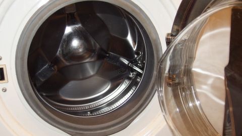 Eine geöffnete Frontlader-Waschmaschine zeigt die leere Trommel, während sie darauf wartet, Wäsche zu waschen.