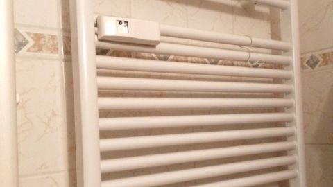 Ein Handtuchheizkörper wärmt in einem Badezimmer, um eine optimale Raumtemperatur zu gewährleisten.