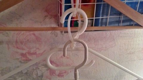Auf einem Kleiderbügel sind mehrere Kabelbinder angebracht, die Kleidung auf platzsparende Weise organisieren.