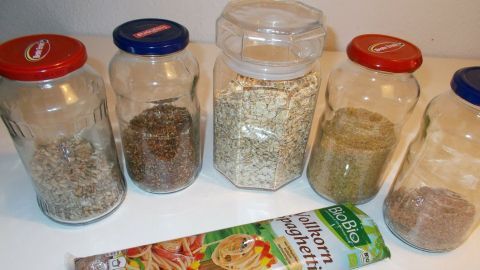 Verschiedene Gläser mit Gewürzen stehen nebeneinander, während eine Packung fettarme Pasta im Vordergrund liegt.
