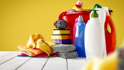 Bunte Reinigungsmittel und Schwämme stehen auf einem Tisch, um Hygienemaßnahmen im Haushalt zu unterstützen.