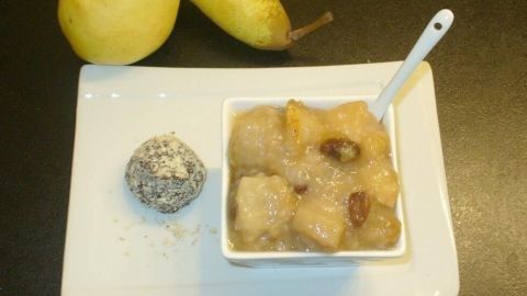 Ein weißes Schälchen mit Birnenkompott und Sago steht auf einem Tisch, daneben liegen zwei frische Birnen.