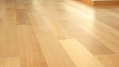 Ein Laminatboden erstreckt sich über den gesamten Raum, in dem das Teppichklebeband entfernt wurde.