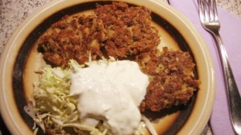 Leckere Haferflocken-Puffer liegen auf einem Teller neben einem frischen Salat und einem cremigen Dip in einer gemütlichen Küche.