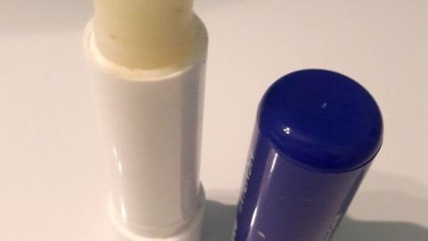 Ein weißer und ein blauer Lippenbalsam stehen auf einem hellen Untergrund, ideal für die Pflege der Augenbrauen.