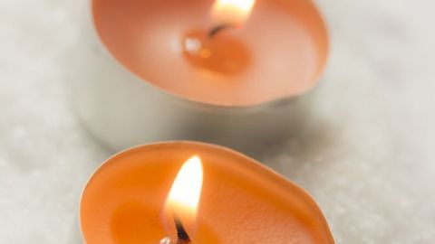 Möchtest du wissen, wie Teelichter, die ja generell nicht so eine lange Brenndauer haben, doch noch etwas länger brennen? Dann lies jetzt diesen Tipp. Zwei brennende Teelichter leuchten auf einer weißen, schneebedeckten Oberfläche und schaffen eine gemütliche Atmosphäre.
