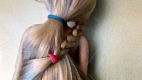Eine Puppe mit langen Haaren hat Zopfgummis in verschiedenen Farben, die ihre Frisur halten und hübsch aussehen.