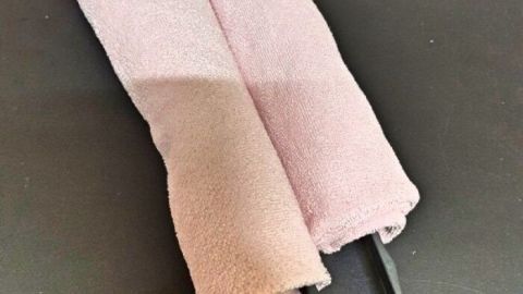 Eine Reinigungsrolle mit zwei Microfasertüchern liegt auf einer schwarzen Unterlage, bereit zum Abstauben von Lamellen Jalousien.